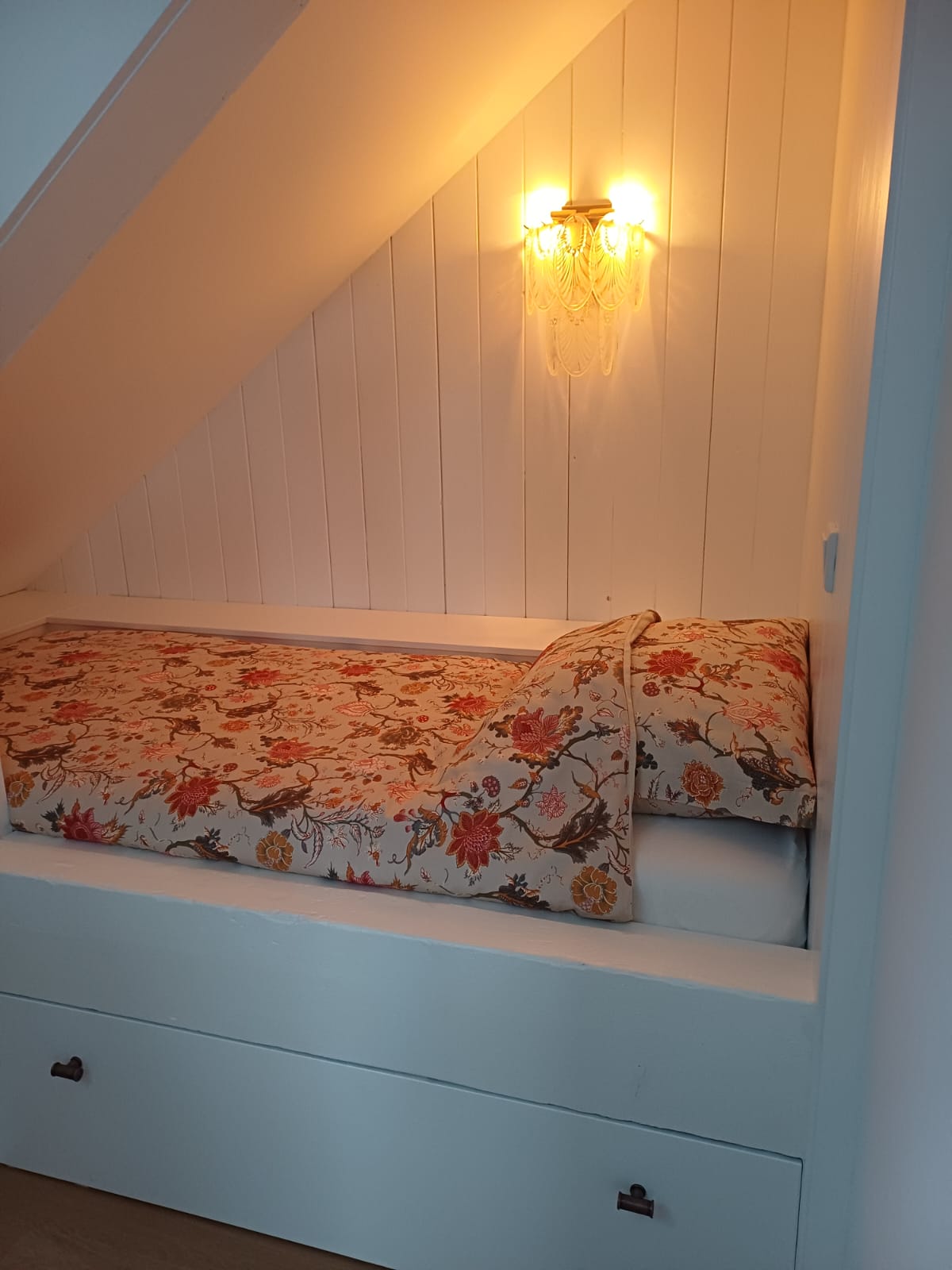 Knusse bedstee onder het schuine dak